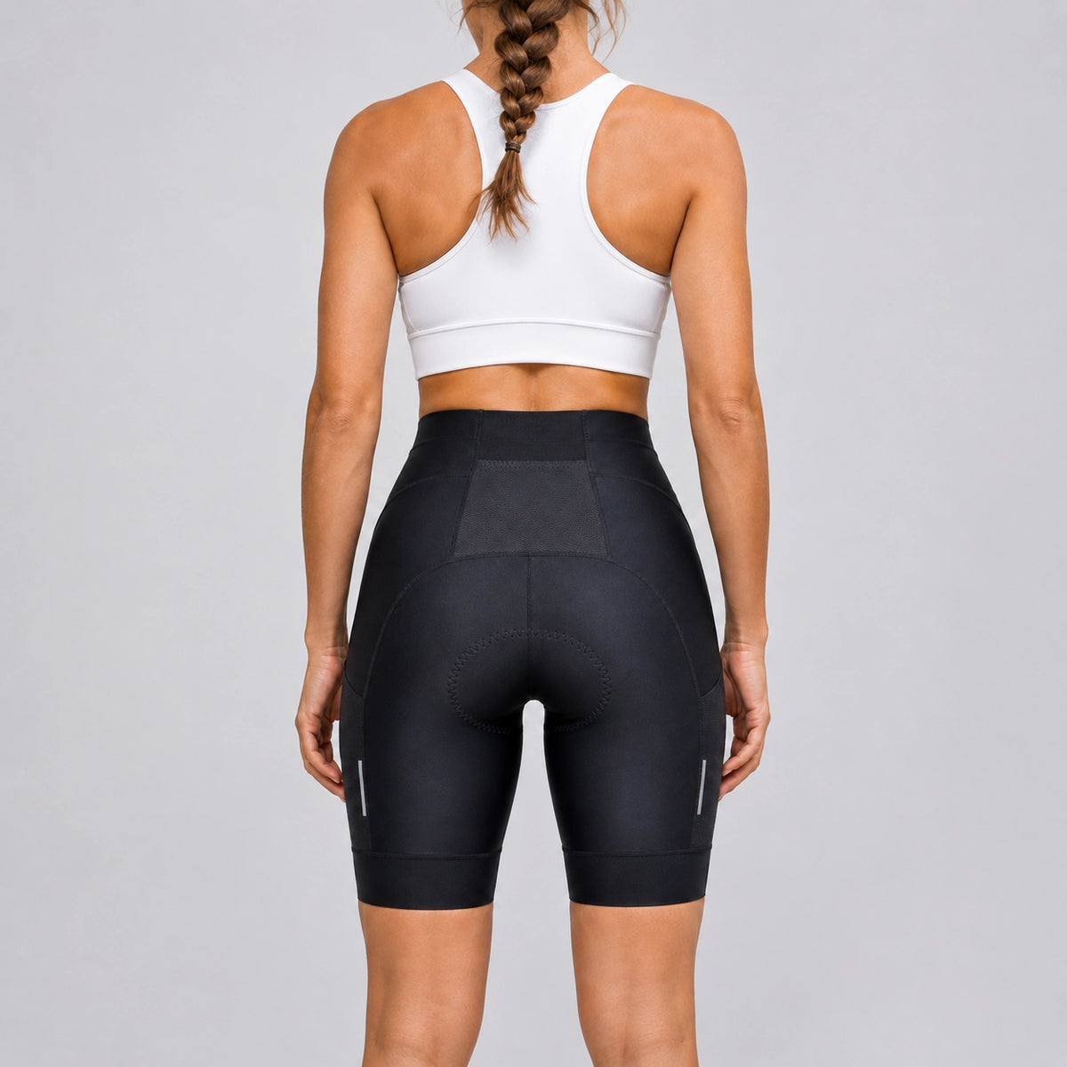 Back view of a model wearing black women's road cycling shorts.
