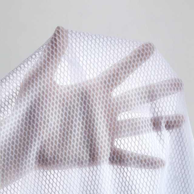 Close-up of white Men's Essential Versatile Cycling Base Layer fabric showing breathable open-mesh texture and lightweight airflow