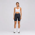 Full-length front view of a model wearing black women's road cycling shorts.