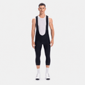 Front view of a model wearing black men's classic 3/4 cycling bib shorts.