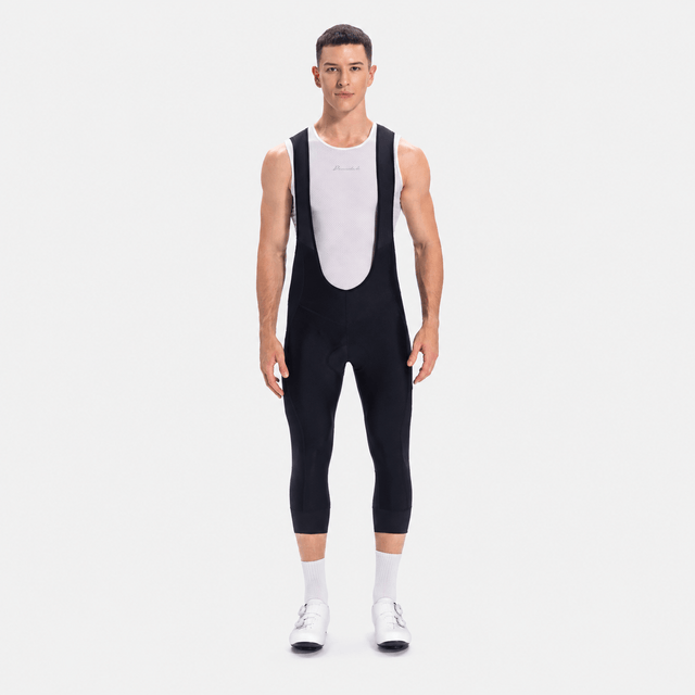 Front view of a model wearing black men's classic 3/4 cycling bib shorts.