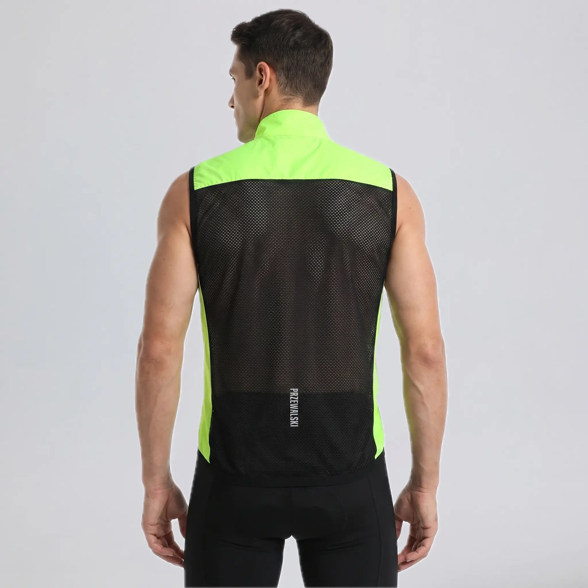 Back view of a model wearing a bright green men's windproof cycling vest with a breathable mesh panel.