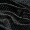 Close-up of the breathable mesh fabric on a black women's windproof cycling vest.