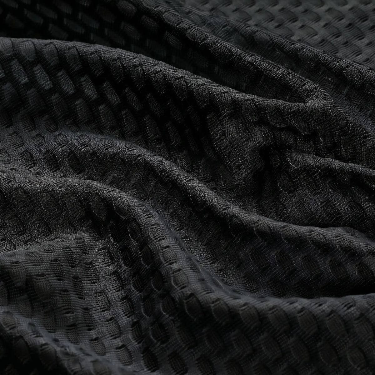 Close-up of the breathable mesh fabric on a black women's windproof cycling vest.