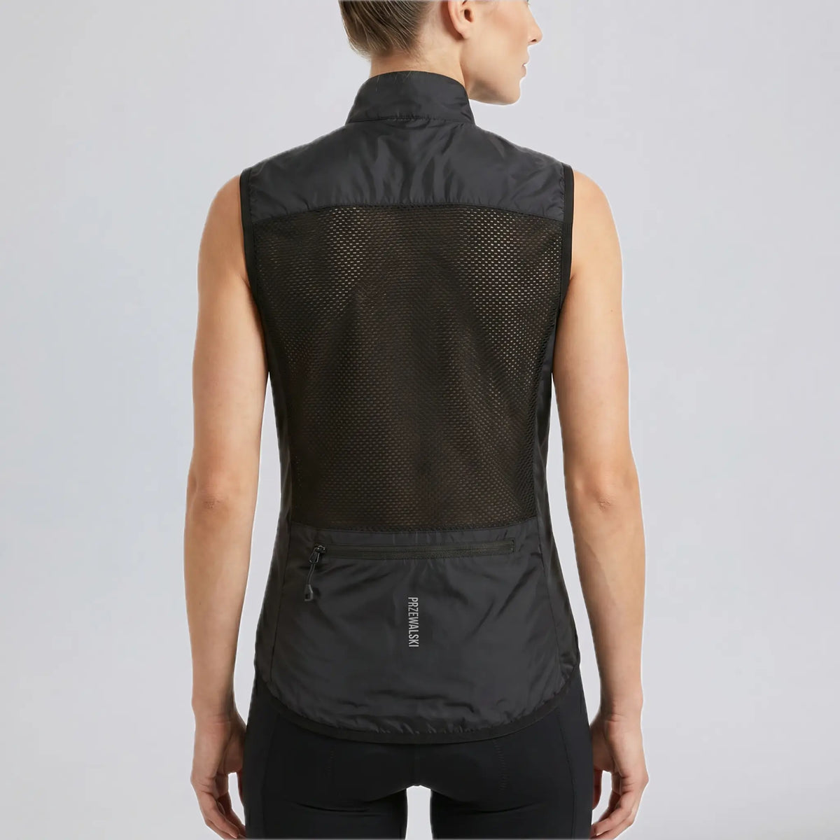 Back view of a model wearing a black women's windproof cycling vest with rear pocket.