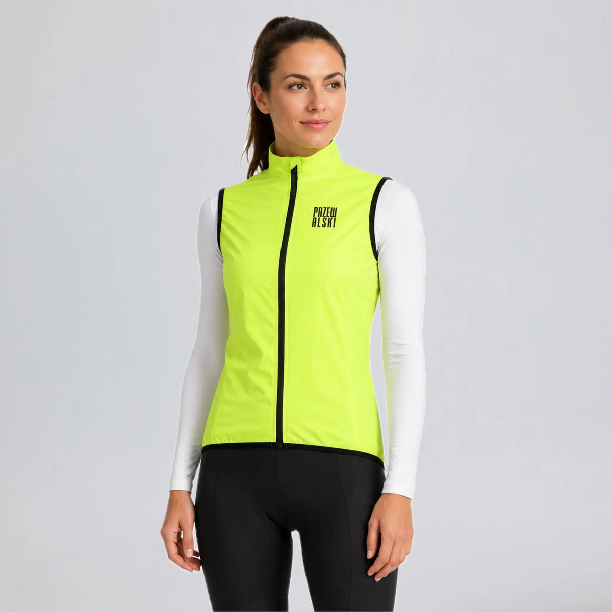 Front three-quarter view of a model wearing a bright green women's windproof cycling vest.
