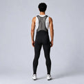 Back view of a model wearing black men's winter fleece road cycling bib tights.