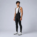Front three-quarter view of a model wearing black men's winter fleece road cycling bib tights.