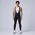 Front view of a model wearing black men's winter fleece road cycling bib tights.