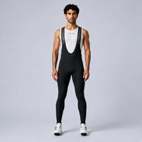 Front view of a model wearing black men's winter fleece road cycling bib tights.