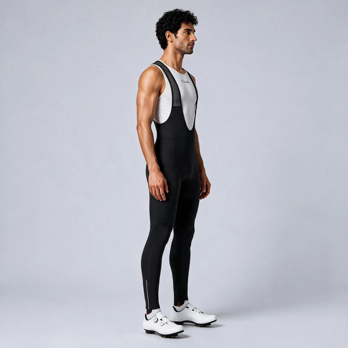 Side view of a model wearing black men's winter fleece road cycling bib tights.
