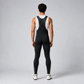 Back view of a model wearing black men's winter thermal road cycling bib tights.