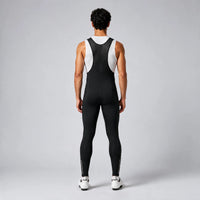 Back view of a model wearing black men's winter thermal road cycling bib tights.