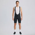 Full-length front view of a model wearing black men's gravel endurance bib shorts.