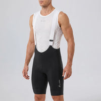 Front three-quarter view of a model wearing black men's MTB endurance bib shorts.