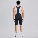 Back view of a model wearing black men's cargo cycling bib shorts.