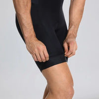 Close-up of a model pulling the leg opening of black men's cargo cycling bib shorts.