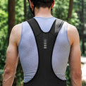 Back view of a cyclist wearing black men's cycling bib shorts.
