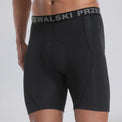 Front three-quarter view of a model wearing black men's padded cycling underwear base shorts.