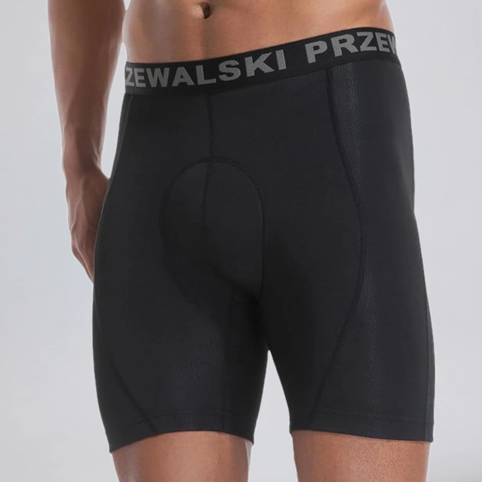 Front three-quarter view of a model wearing black men's padded cycling underwear base shorts.